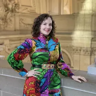 Kate Patterson posing in a colorful dress inside City Hall. 